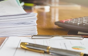 stack of business paper with pen and calculator | commercial property floor cleaning service